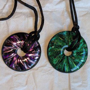 Two green and purple glass pendants